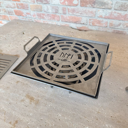Grille de barbecue en métal découpée au laser avec motif circulaire et poignées.