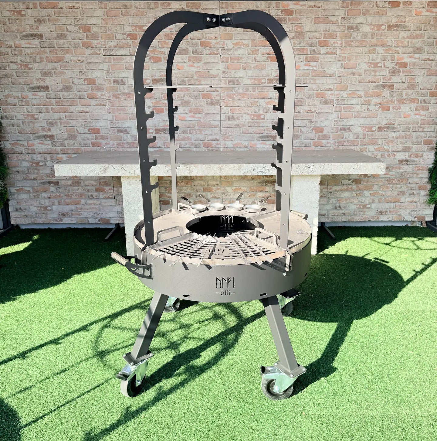 Barbecue circulaire en métal sur roulettes avec support de cuisson et structure haute