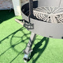 Brasero métallique avec grille de cuisson et roulettes sur pelouse synthétique