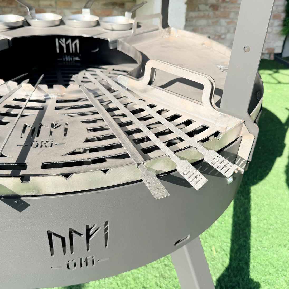 Barbecue en métal avec grille de cuisson et ustensiles de cuisine en acier.