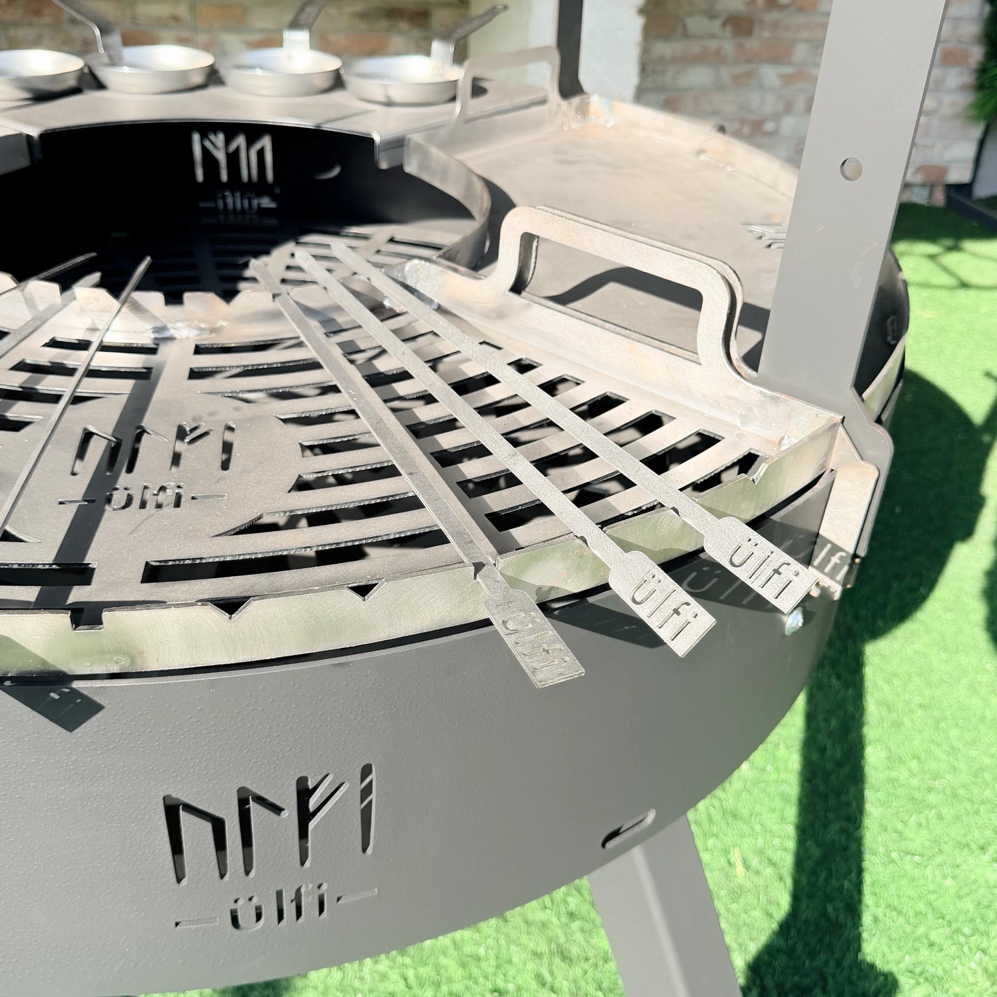 Barbecue en métal avec grille de cuisson et ustensiles de cuisine en acier.