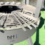 Barbecue en métal avec grille de cuisson et ustensiles de cuisine en acier.