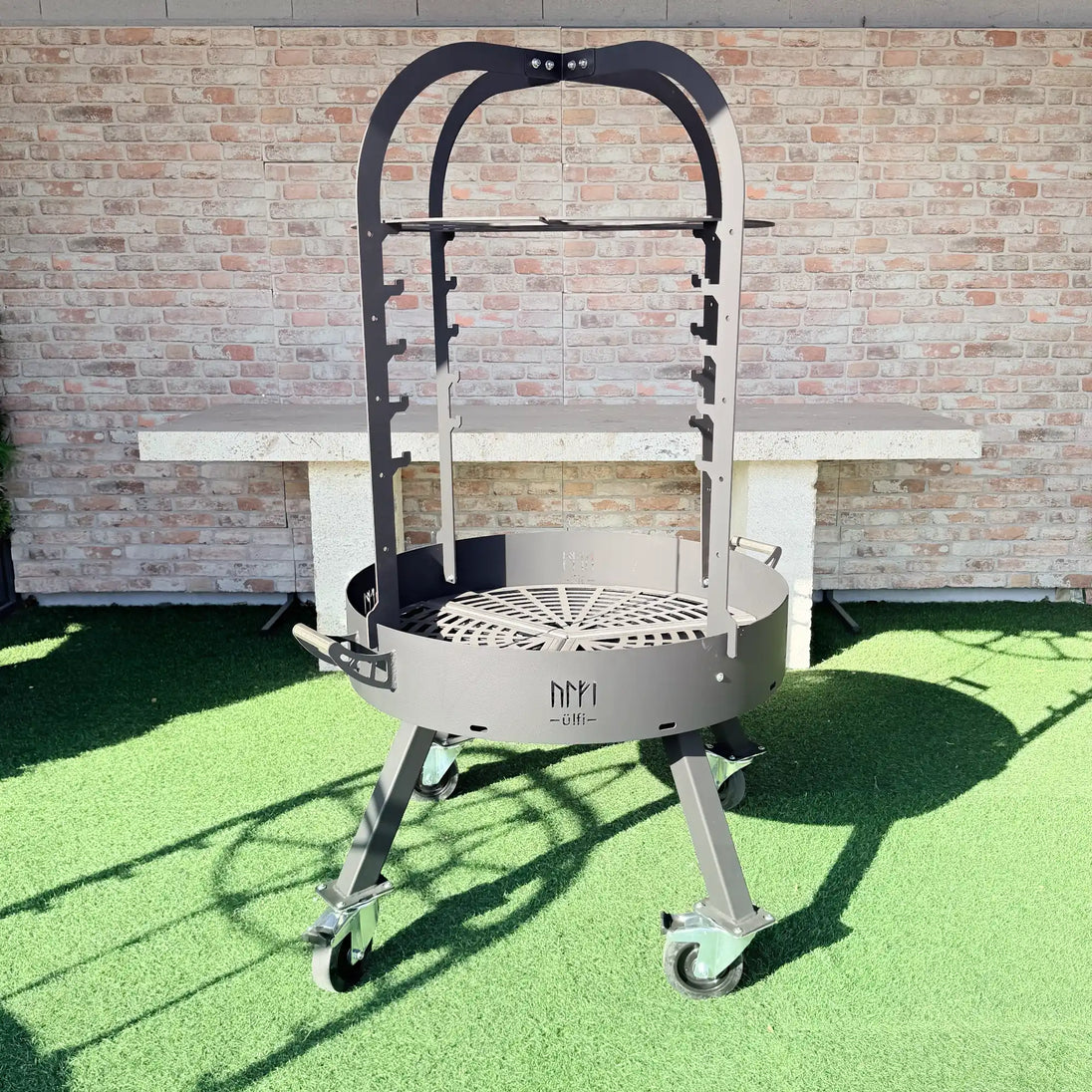 Barbecue circulaire en métal noir sur roulettes avec support de cuisson
