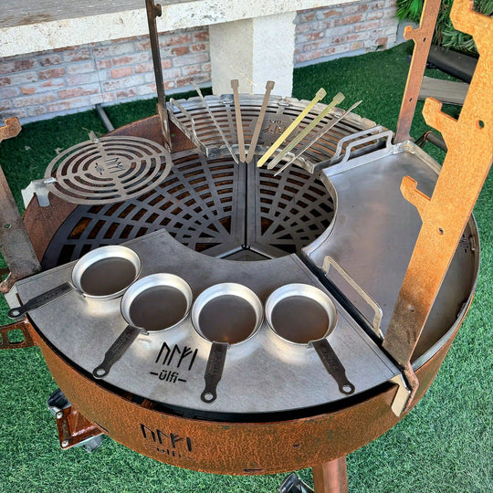 Barbecue en métal avec accessoires de cuisson et petits poêles en acier.