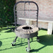 Brasero de jardin en métal noir avec roulettes et grille de cuisson sur gazon